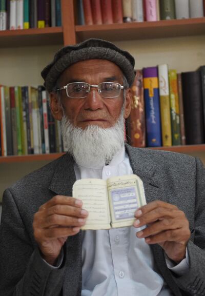 In this photo taken on October 11, 2018, Afghan man Abdul Karim, 85, poses for a picture as he holds his id card or Tazkira registered to vote in the upcoming parliamentary election, in Kabul. Bloody violence has forced thousands of polling centres to close and stopped millions of people from registering to vote. But war-torn Afghanistan's long-delayed legislative election will still go ahead on October 20, officials say. Almost nine million people are eligible to vote in the ballot, which is more than three years late and largely funded by the international community.
 / AFP / WAKIL KOHSAR
