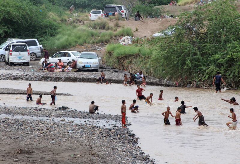 Yemenis take advantage of floodwater to cool down, in Lahj Governorate.