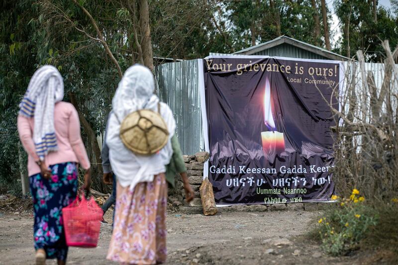 Women walk past a memorial banner set up by local residents near the memorial service for the one-year anniversary of the crash of Ethiopian Airlines Flight ET302 in the rural Tulufera area near Bishoftu in Ethiopia. AP Photo