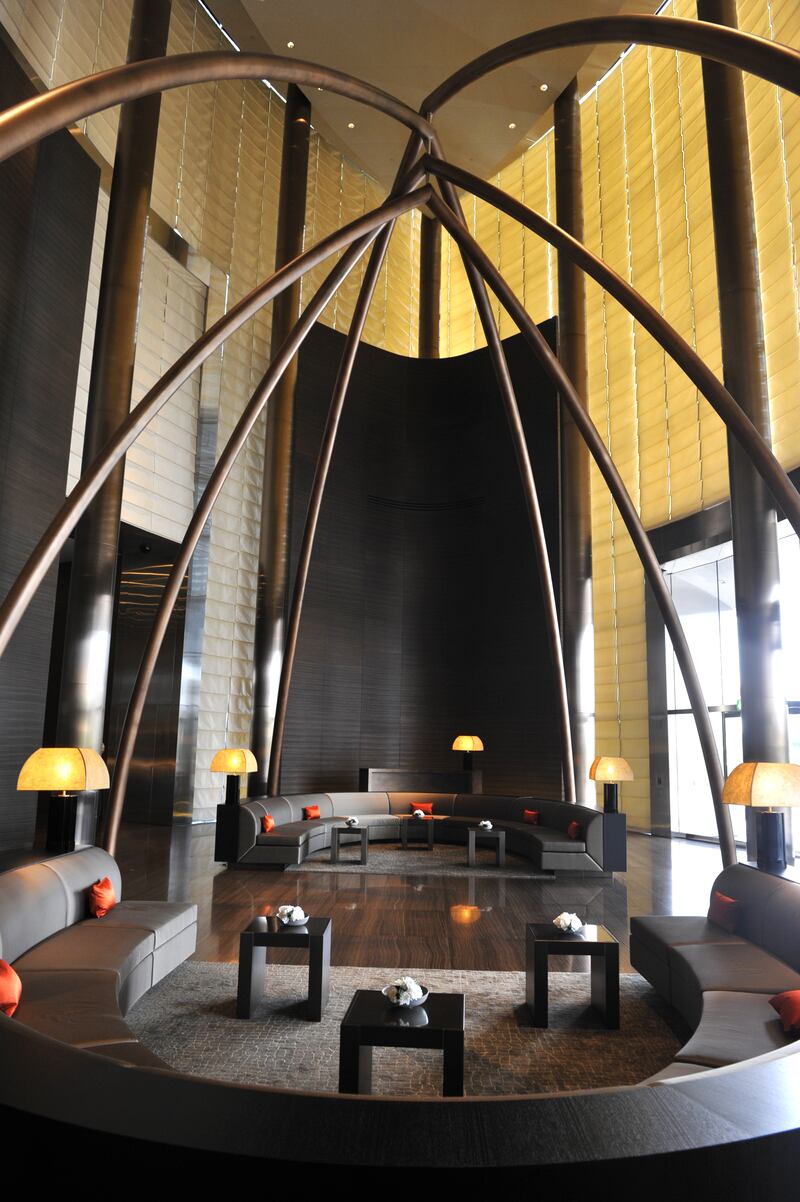 Visitors step into the hotel lobby, under looming bronze arches. Photo:  Max Montingelli / SGP / Armani Hotel Dubai