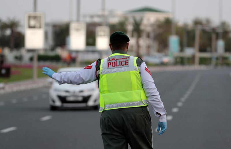 DUBAI, UNITED ARAB EMIRATES , April 16– 2020 :- Dubai Police officer stopping the private vehicles and checking the movement permit near Madinat Jumeirah in Dubai. Dubai is conducting 24 hours sterilisation programme across all areas and communities in the Emirate and told residents to stay at home. UAE government told residents to wear face mask and gloves all the times outside the home whether they are showing symptoms of Covid-19 or not.  (Pawan Singh / The National) For News/Online/Instagram