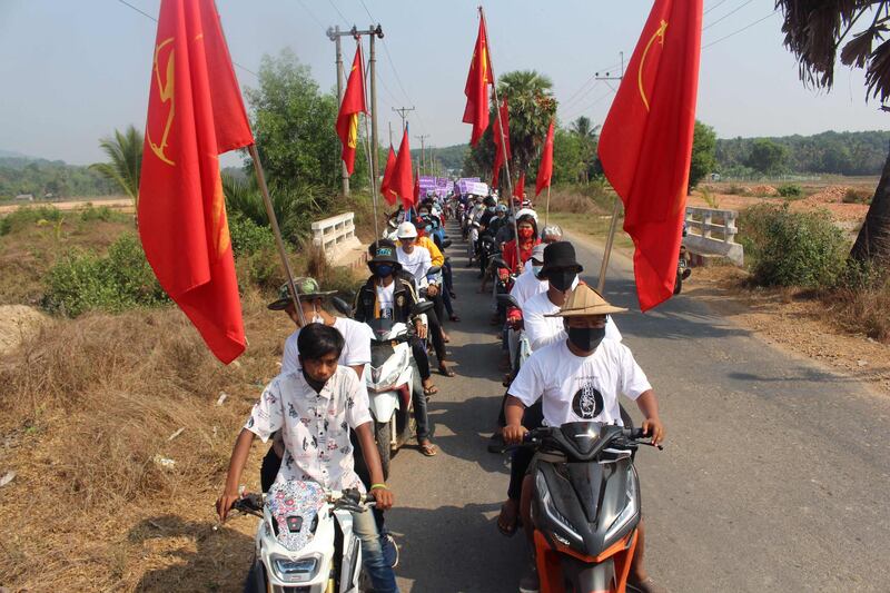 Protesters with flags take part in a demonstration against the military coup as they ride scooters through a rural part of Launglone township in Myanmar's Dawei district. AFP