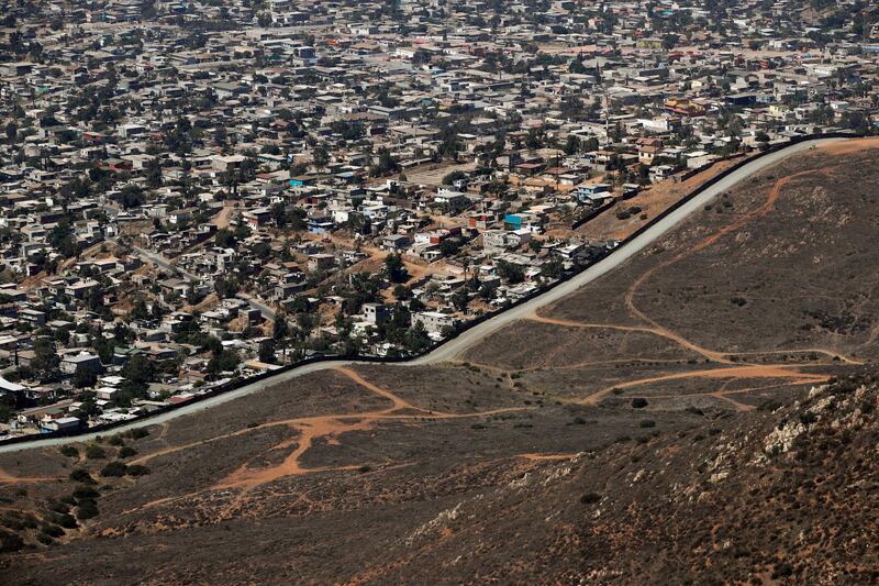 A road runs alongside a border wall that separates Tijuana, Mexico, top, from San Diego, in San Diego. AP Photo / Jae C. Hong