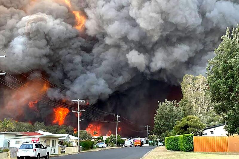 Flames from an out of control bushfire seen from a nearby residential area in Harrington, some 335 kilometers northeast of Sydney. AFP