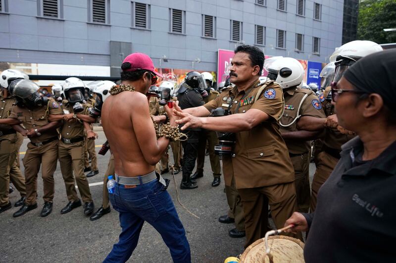A police officer pushes a protester. AP