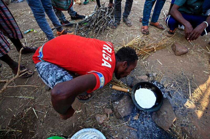 Ethiopian refugees who fled fighting in Tigray province cook outdoors on a three-stone fire, at the Um Rakuba camp in Sudan's eastern Gedaref province.  AFP