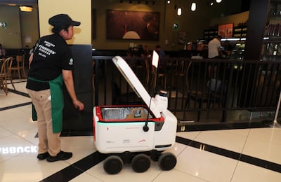 A delivery robot picking up an order from Starbucks to take to Dubai Silicon Oasis. Pawan Singh / The National