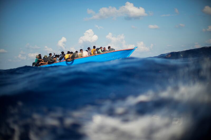 Migrants sail a wooden boat south of Italy's Lampedusa island in the Mediterranean sea in August. AP