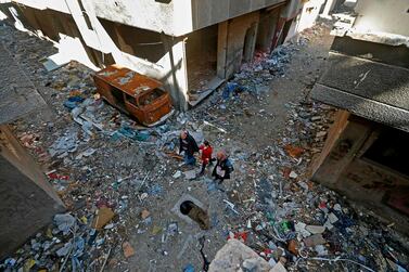 Issa Al Loubani, 48, a Palestinian refugee, walks with his wife and daughter in Yarmouk, a settlement on the southern outskirts of Damascus. AFP