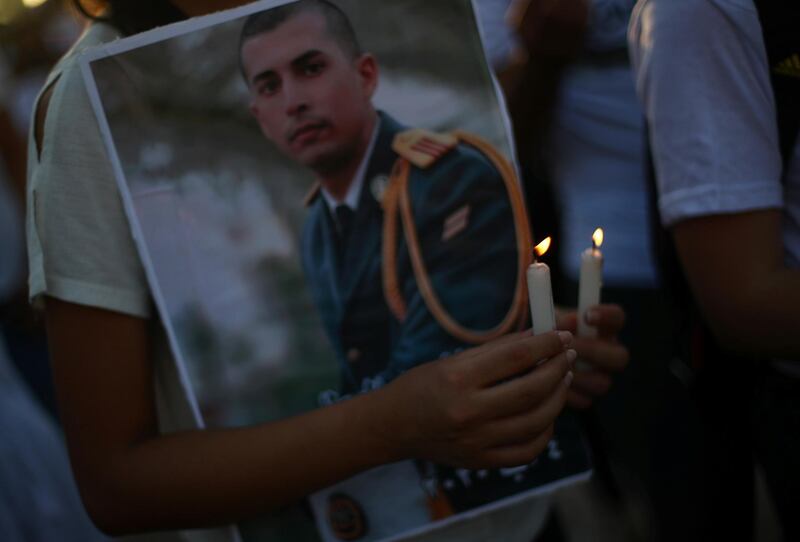 A person holds candles during a vigil for the people killed in a massive explosion, in Beirut. Reuters
