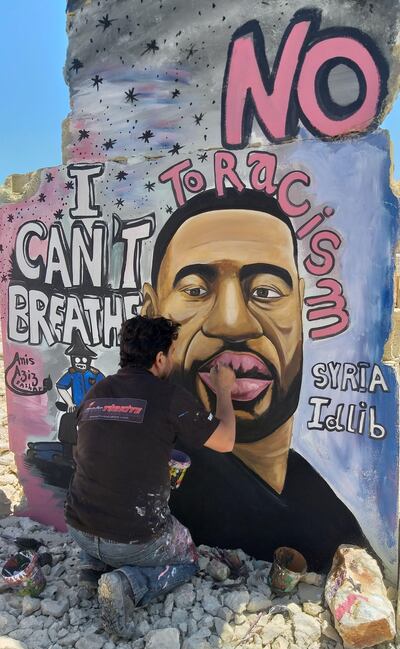 Syrian artist Aziz Asmar painting a mural of George Floyd in Idlib, Syria, with the words 'I can't breathe'. Asmar says the work has been well received internationally. Aziz Asmar