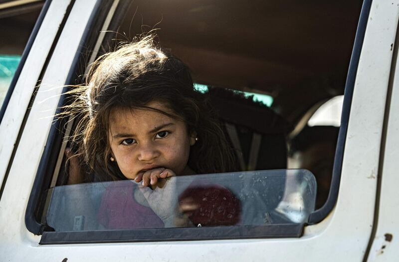 A young Syrian girl fleeing with her family from Ras Al Ain peeks out of a car window as Syrian Arabs and Kurds moving away from the battle zone between Turkey-led forces and Kurdish fighters from the Syrian Democratic Forces (SDF), arrive in the city of Tal Tamr on the outskirts of Hasakeh. AFP
