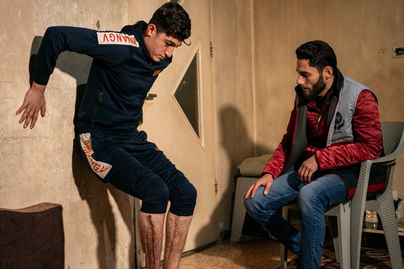 Mustafa performs strength-building exercises under the guidance of Mr Bardoush. He lost a brother in the earthquake and has undergone many operations