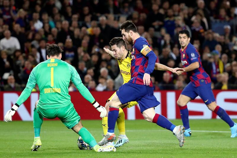 Barcelona's Lionel Messi, center, tries to round Dortmund goalkeeper Roman Burki. AP