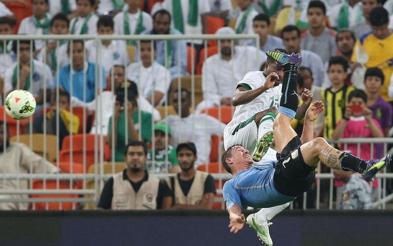 Uruguay's Cristian Rodriguez, below, attempts a bicycle kick against Saudi Arabia's Nassir Al Shamrani during an international friendly on Friday. AFP Photo / October 10, 2014