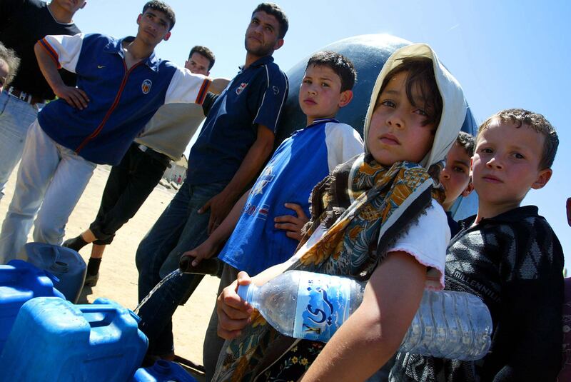 Survivors line up for water at a make-shift camp in Bordl Manaiel, Algeria, after a 6.8 magnitude quake rocked the North African country in May 2003, killing more than 2,630