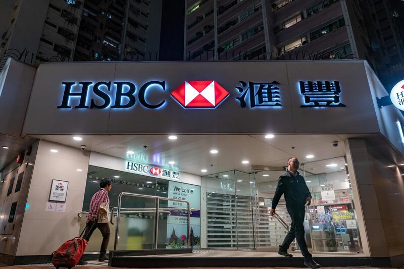 Customers exit and enter an HSBC Holdings Plc bank branch at night in Hong Kong, China, on Saturday, Feb. 16, 2019. HSBC is scheduled to release full year earnings results on Feb. 19. Photographer: Anthony Kwan/Bloomberg