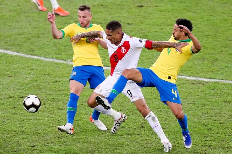 Peru's Paolo Guerrero goes for the ball with Brazil players Marquinho, right, and Arthur. AP Photo