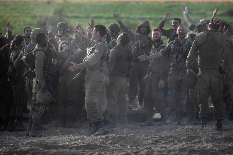 Israeli soldiers cheer as they take photos at an artillery position along the Israel-Gaza border. AP Photo
