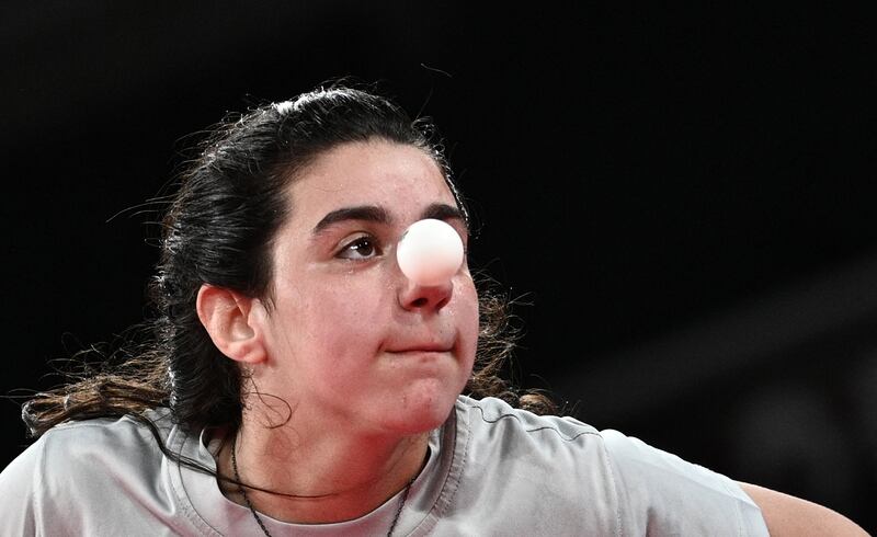 Syria's Hend Zaza serves to Austria's Liu Jia during their women's singles preliminary round table tennis match at the Tokyo Metropolitan Gymnasium.