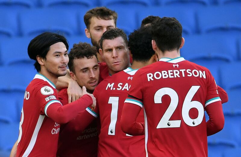 Liverpool's Diogo Jota , second left, is mobbed by teammates after scoring. AFP