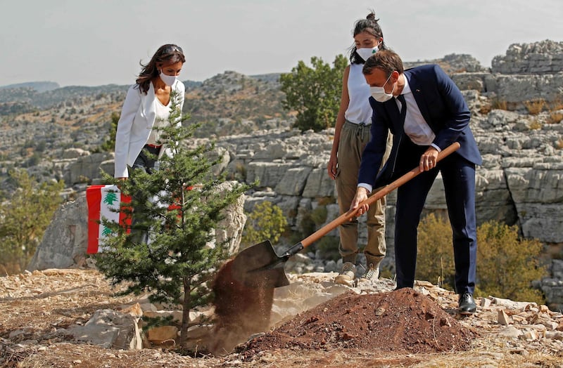 Emmanuel Macron plants a cedar tree alongside members of the NGO Jouzour Loubnan during a ceremony marking Lebanon's centenary in Jaj Cedar Reserve Forest, north-east of Beirut, on September 1, 2020. AFP