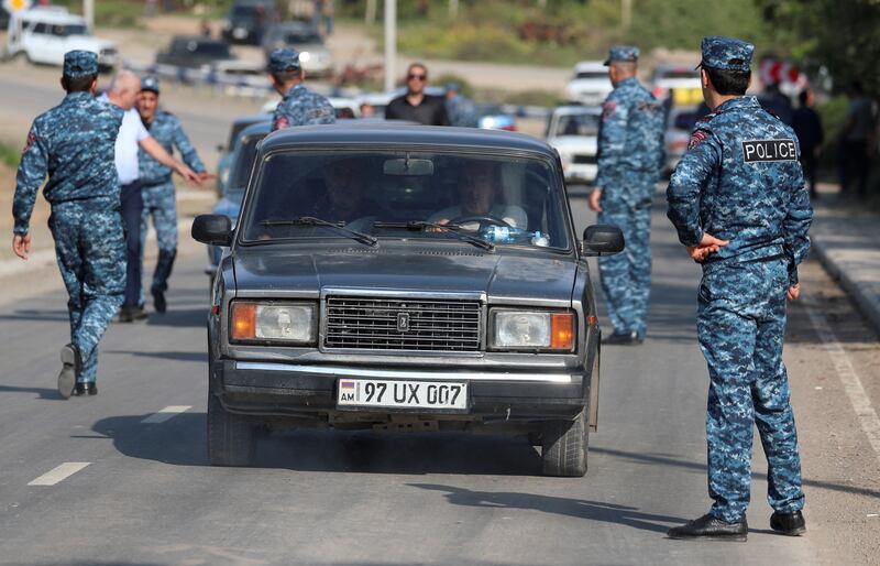 Refugees from Nagorno-Karabakh region drive cars past an Armenian checkpoint. Armenia's Prime Minister has warned of ethnic cleansing and accused Russia of failing to provide security. Reuters