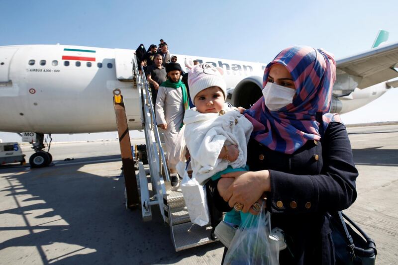 Passengers wearing protective masks disembark from a plane upon their arrival at Najaf airport, amid the new coronavirus outbreak, Iraq. Reuters