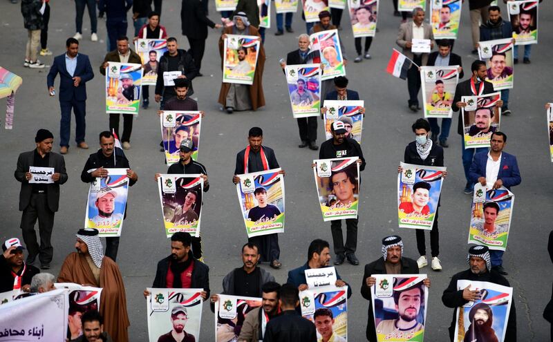 Supporters of Iraqi Shiite group Popular Crowd Forces and Iraqi Shiite Muslim spiritual leader Grands Ali al-Sistani carry the pictures of the victims of protests as they take part in a demonstration at the Al Tahrir square in central Baghdad.  EPA