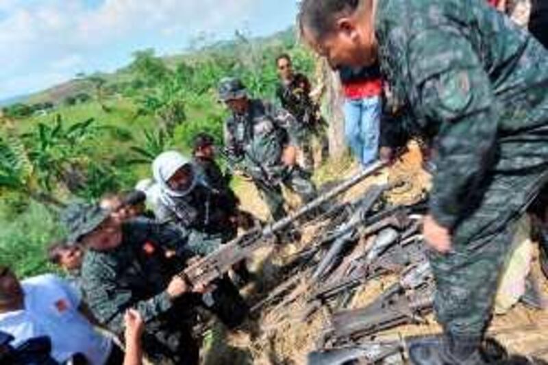 CORRECTION
Police officials shows a .50 caliber machine gun unearthed along with a cache of weapons at a property believed to be owned by the governor of Maguindanao in Datu Hoffer on the outskirts of the provincial capital, Shariff Aguak, in the southern Philippine province of Maguindanao on December 6, 2009.  About 40 firearms, including M16 assault rifles, were uncovered on the property that is believed to be owned by the governor of Maguindanao province, Andal Ampatuan Sr., military spokesman Lieutenant Colonel Michael Samson told AFP at the site.    AFP PHOTO / TED ALJIBE