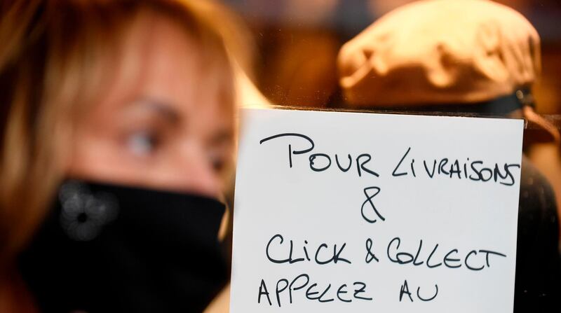 A signs stuck to the window of a shop reads 'for delivery and click and clootect call ...' in Paris on November 3, 2020, as nonessential buisnesses are closed due to the new lockdown to curb the spred of the novel coronavirus, Covid-19.  / AFP / ERIC PIERMONT
