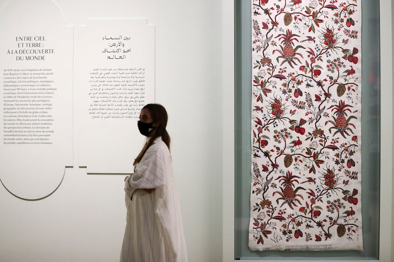 A visitor in front of 'Grand Ananas' pineapple fabric, woodblock-printed cotton with brushwork, circa 1777, on display at the exhibition.