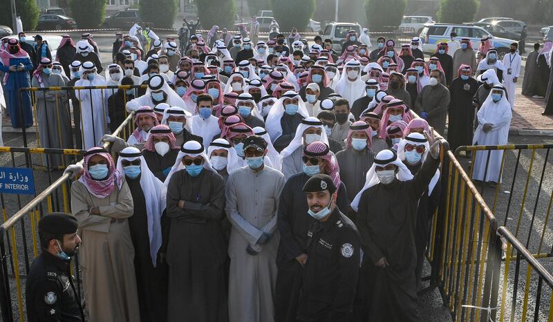 People wearing protective masks arrive to cast their vote at a polling station in Kuwait City. EPA