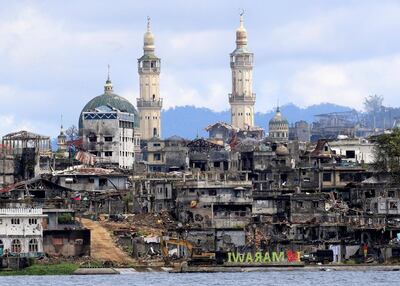 A signage of "I love Marawi" is seen in front of damaged houses, buildings and a mosque inside a war-torn Marawi city, southern Philippines October 26, 2017, after the Philippines on Monday announced the end of five months of military operations in a southern city held by pro-Islamic State rebels. REUTERS/Romeo Ranoco     TPX IMAGES OF THE DAY