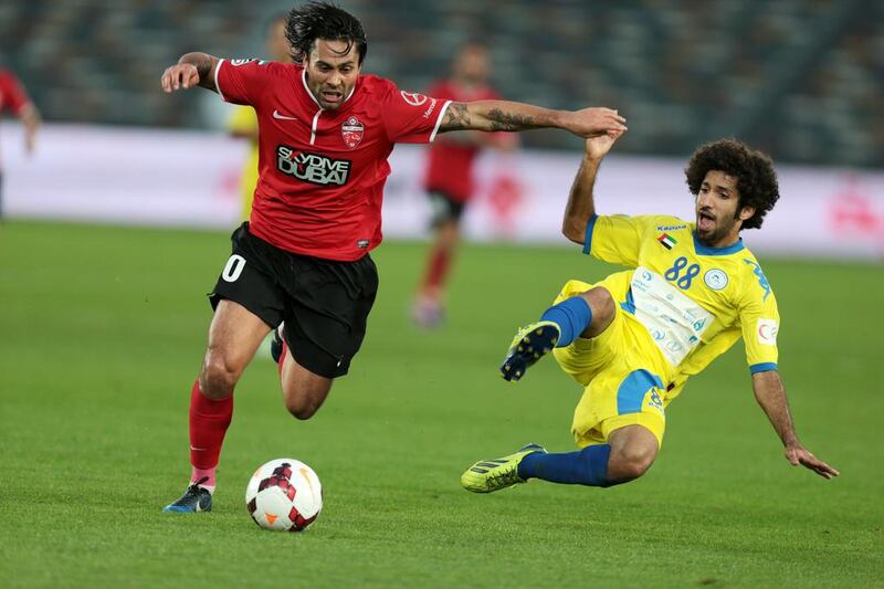 Al Ahli’s Luis Antonio, right, challenges Al Dhafra’s Abdalla Al Naqbi for possession of the ball during a President’s Cup semi-final match in Abu Dhabi on Thursday night. Christopher Pike / The National