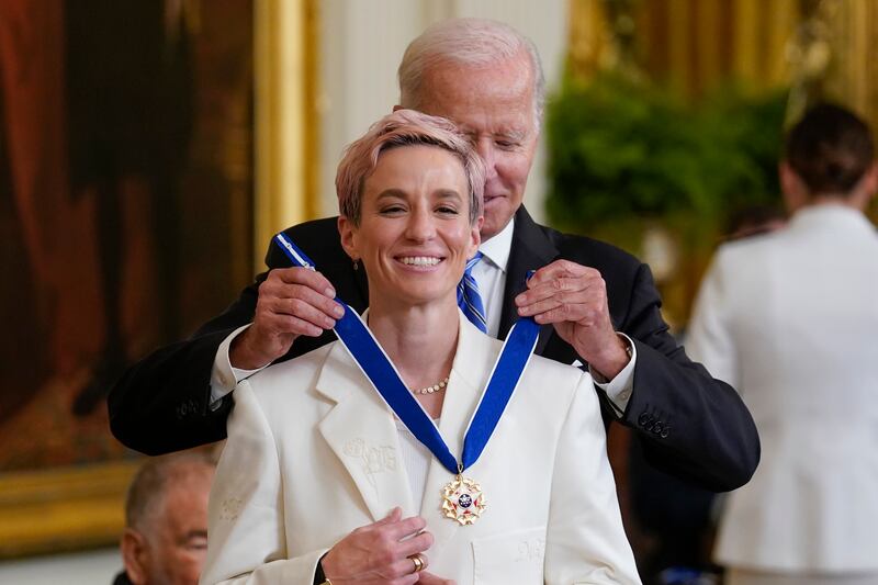 Mr Biden awards football star and activist Megan Rapinoe at the White House. AP