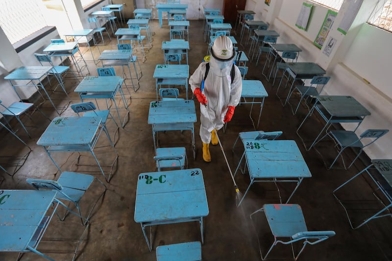 A St. John Ambulance volunteer sprays disinfectant at a  secondary school in Colombo, Sri Lanka. EPA