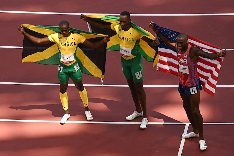 Third-placed Jamaica's Ronald Levy, left, first-placed Jamaica's Hansle Parchment and second-placed USA's Grant Holloway celebrate after competing in the men's 110m hurdles final.