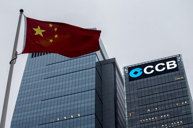 FILE PHOTO: A Chinese national flag flies in front of the China Construction Bank (CCB) Tower at Hong Kong's Central business district December 26, 2014.   REUTERS/Tyrone Siu//File Photo