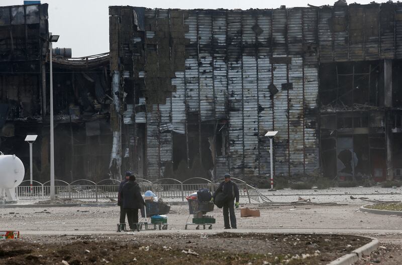 People use carts to transport their belongings in Mariupol. Reuters