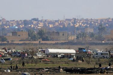 ISIS members walk in the Syrian village of Baghouz, close to the border with Iraq, before the village was liberated in February 2019. Reuters