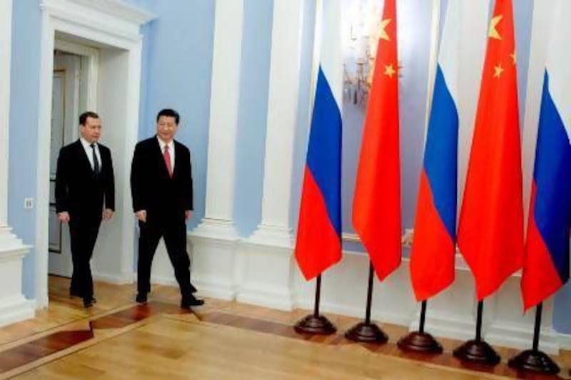 The Russia prime minister Dmitry Medvedev, left, and Chinese President Xi Jinping enter a hall during their meeting at Mr Medvedev's Gorki residence outside Moscow. EPA / Dmitry Astakhov / Ria Novosti / Government Press Service / Pool