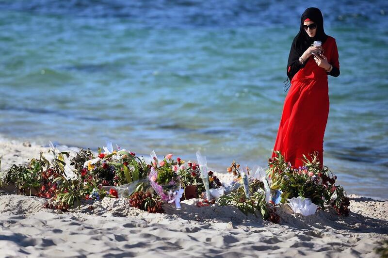 A woman looks at flowers laid on Marhaba beach in Sousse, where 38 people were killed in a terror attack. Getty