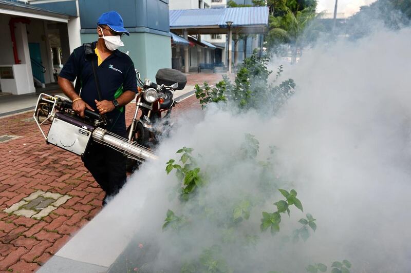 A pest control worker fumigates a residential compound in the Bedok North area of Singapore. Twenty-two new Zika cases were reported on Wednesday in one area of the city. Roslan Rahman / AFP