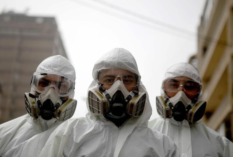 Employees of a Lebanese public health company wear protective gear in Beirut.  AFP