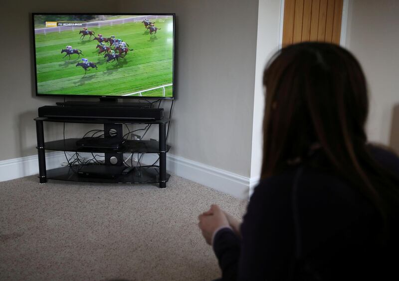 A racing enthusiast watches the Virtual Grand National at home in Davenham. Reuters