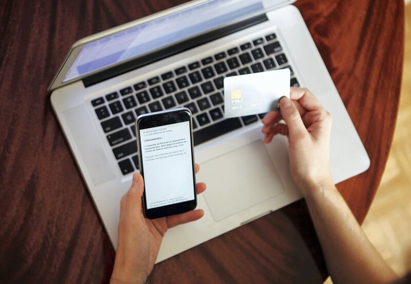 Overhead view of woman with laptop holding credit card and smartphone. *** Local Caption *** 00233377