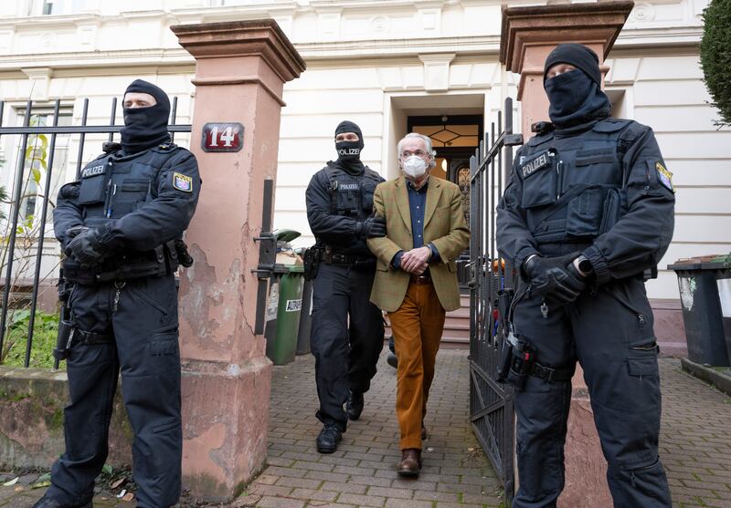 German police lead out Prince Heinrich XIII during a raid in Frankfurt. Twenty-five suspected members of a far-right group have been detained across Germany. Getty Images