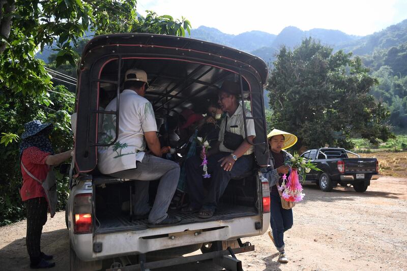 Visitors boarding a shuttle car to take them to the entrance of the Tham Luang cave. AFP