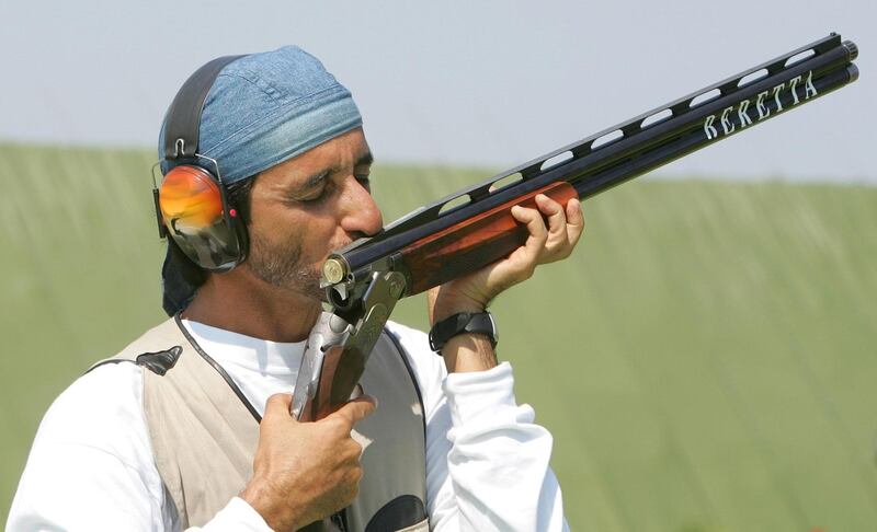 Sheikh Ahmed Al-Makoum of United Arab Emirates kisses his gun after he won the men's double trap final of the Athens 2004 Olympic Games in Athens, August 17, 2004. Almakyoum took gold with a score of 189. REUTERS/Guang Niu  GN/DL